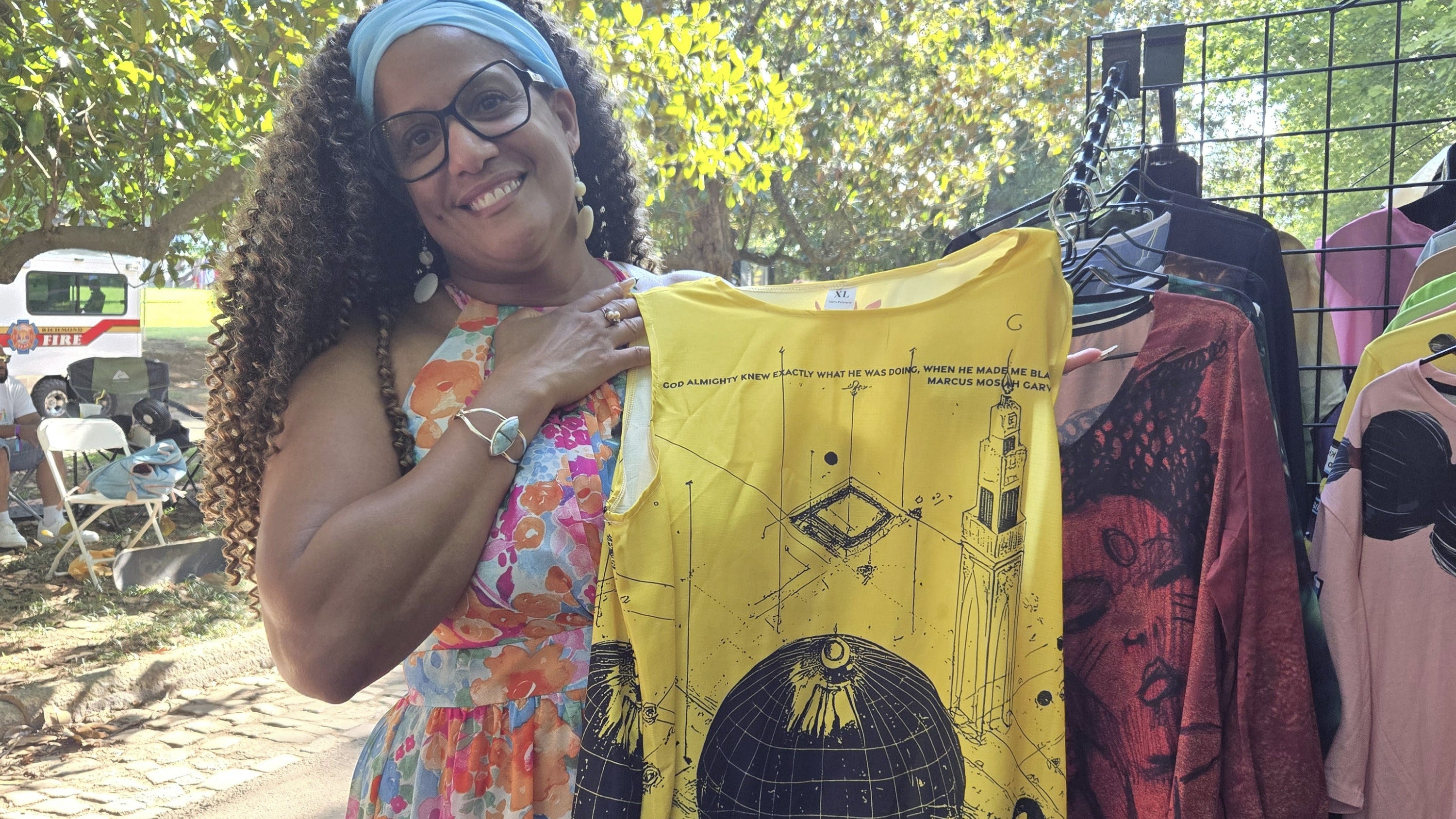 Woman holding our "God knew" dress dress with a yellow background and black design.